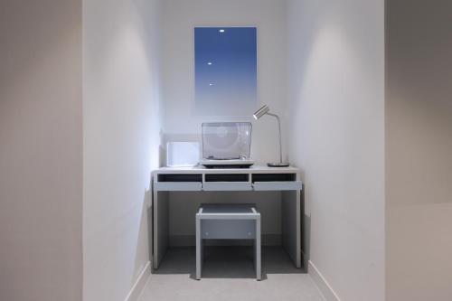 a desk with a tv and a lamp on it at Aank Air Hotel Daejeon in Geochang