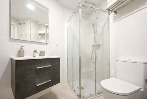 uma casa de banho com um chuveiro, um WC e um lavatório. em New studio, terrace, parking, and pool by 10ToSea em Fuengirola