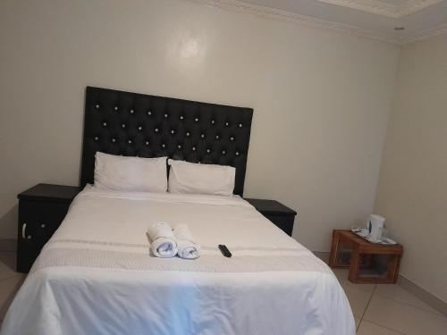 a bedroom with a bed with two rolled up towels at Rest Camp Lodge in Manzini