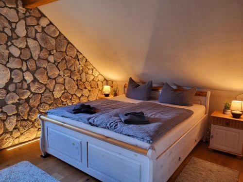 a bedroom with a bed with a stone wall at Wellnessparadies mit Sauna und Whirlpool Ferienhaus Wiesenblick in Krakow am See