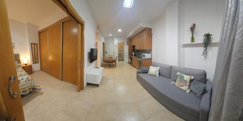 a living room with a couch and a kitchen at Apartamento con piscina y cerca de la playa in Canet de Berenguer