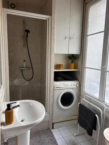 une salle de bain avec une machine à laver et un lavabo dans l'établissement Appartement au coeur de paris à 1 kilomètre de la Tour Eiffel, à Paris