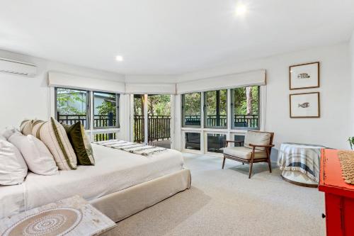 a bedroom with a large bed and a chair at Dual-living amongst the rainforest, Little Cove in Noosa Heads