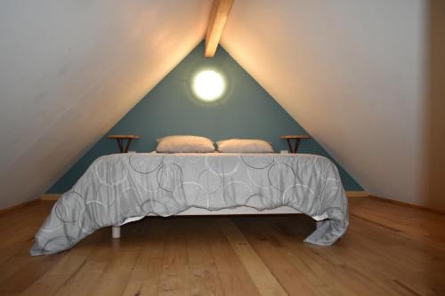 ein Schlafzimmer mit einem Bett im Dachgeschoss in der Unterkunft Gîte de montagne Le Batoua in Sailhan