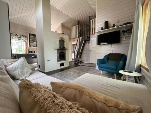 a bedroom with a bed and a blue chair at Käpälämäki puhtaan veden äärellä omassa rauhassa in Enonkoski