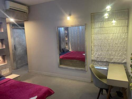um quarto com um espelho, uma mesa e uma cama em Royal Nest (AS) 3 BHK Suite em Pune