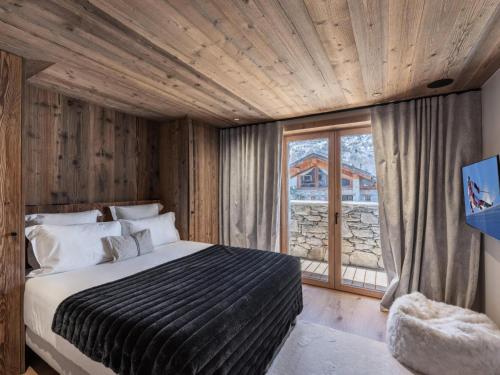 a bedroom with a bed and a large window at Chalet Marcel - Chalets pour 12 Personnes 691 in Saint-Marcel