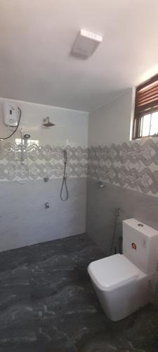La salle de bains est pourvue de toilettes et d'une douche. dans l'établissement Sundill Green Homestay, à Tangalle