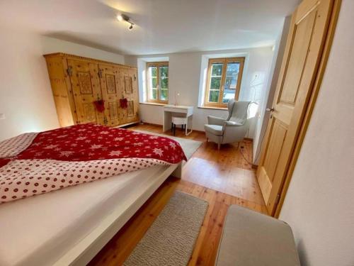ein Schlafzimmer mit einem Bett und einem Stuhl darin in der Unterkunft 70 qm trendig und komfortabel in Engadiner Haus - ENGADIN HOLIDAYS in Guarda