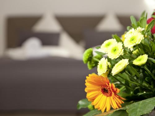 a bouquet of yellow and white flowers in a vase at Central City Hotel in Füssen