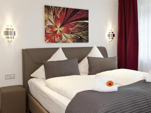 two beds in a hotel room with a picture on the wall at Central City Hotel in Füssen