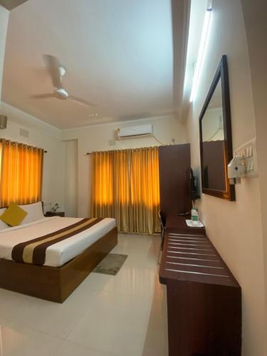 a bedroom with a bed and a desk and a television at Krishna Kunja " A Quiet & Peaceful Stay " in Kolkata