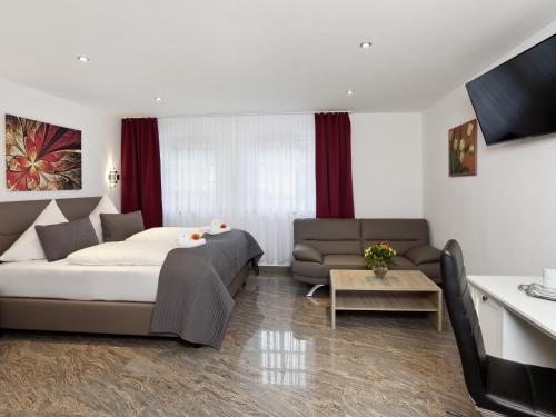 a living room with a bed and a couch at Central City Hotel in Füssen