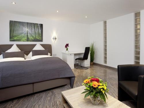 a bedroom with a bed and a table with a vase of flowers at Central City Hotel in Füssen