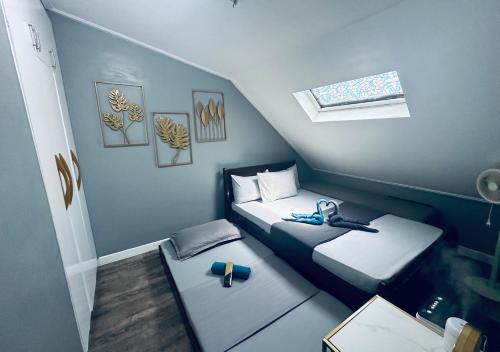 ein kleines Zimmer mit 2 Betten und einem Fenster in der Unterkunft The Penthouse Zonevill Condo in Baguio City