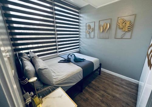 ein kleines Bett in einem Zimmer mit Fenster in der Unterkunft The Penthouse Zonevill Condo in Baguio City