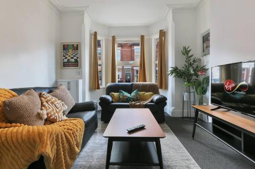 a living room with a couch and a tv at 5 Beds Sleeps 8 Contractor House Permit Park in Nottingham
