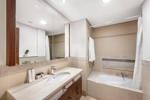 a bathroom with two sinks and a large mirror at FIRST CLASS 1BR Beautifully Furnished in Dubai