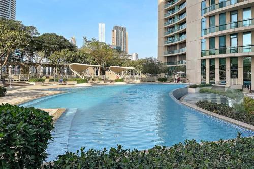 a large swimming pool in a city with buildings at FIRST CLASS 1BR Beautifully Furnished in Dubai