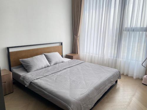 ein Schlafzimmer mit einem Bett und einem großen Fenster in der Unterkunft Lumiere Riverside - Căn hộ tại quận 2 - Thảo Điền in Ho-Chi-Minh-Stadt