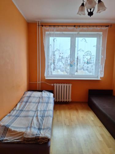 a bedroom with a bed in front of a window at Apartament Stalowa Wola centrum in Stalowa Wola