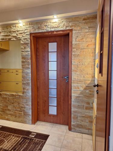a wooden door in a room with a stone wall at Apartament Stalowa Wola centrum in Stalowa Wola