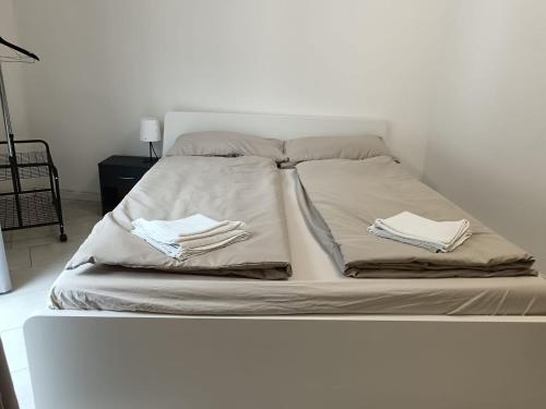 a white bed with two towels on top of it at Apartaments and Rooms Claudia Augusta in Bolzano