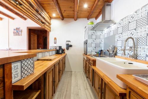 een keuken met houten werkbladen en een witte wastafel bij Appartement Albiez Montrond in Albiez-Montrond