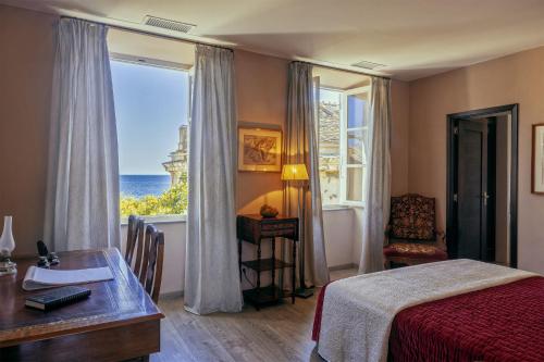 1 dormitorio con cama, escritorio y ventana en Villa les Roses, en Brando