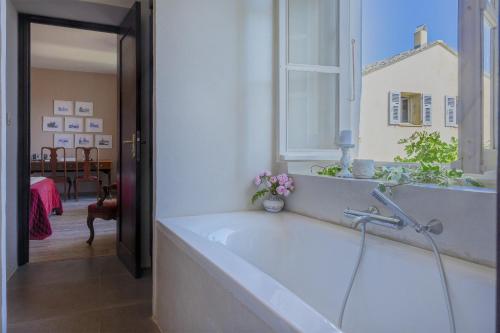 a bathroom with a bath tub with a window at Villa les Roses in Brando