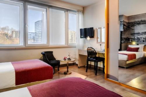 a hotel room with two beds and a desk at Cheya Beşiktaş Istanbul Bosphorus City Center Hotel & Suites in Istanbul