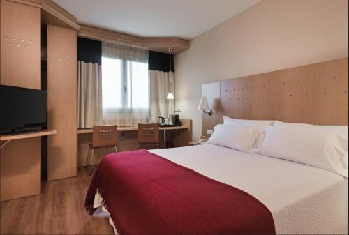 Habitación de hotel con cama grande y escritorio. en Hotel Logroño, en Logroño