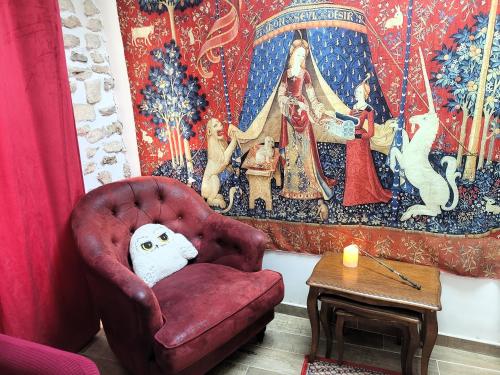 ein Wohnzimmer mit einem roten Stuhl und einem Tisch in der Unterkunft La demeure des maraudeurs -10min Disney-Jardin & BBQ in Villiers-sur-Morin