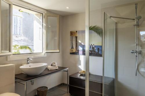 a bathroom with a sink and a shower at Villa la Rose des Mers in Brando
