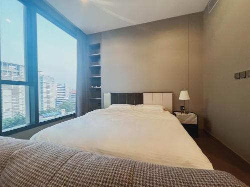 a bedroom with a large bed and a large window at Cozy 1-BR Luxury Getaway in the Heart of Bangkok in Bangkok