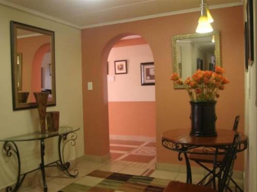a hallway with a table with a vase of flowers on it at Queen's Place in Johannesburg