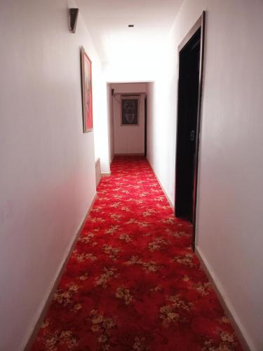 um longo corredor com um tapete vermelho e uma porta em Jada Lifestyle & Lounge em Lagos