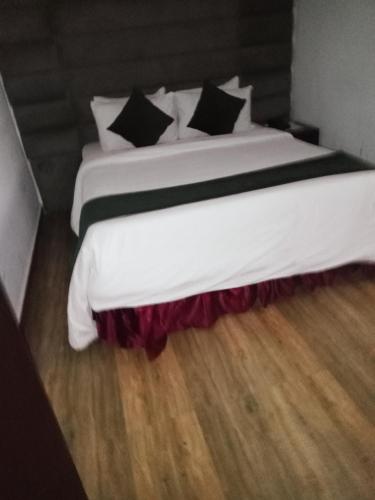 a bedroom with a large white bed with black pillows at Jada Lifestyle & Lounge in Lagos