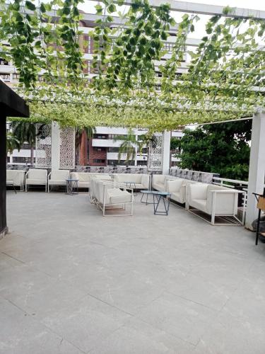 ラゴスにあるJada Lifestyle & Loungeの白い椅子と植物のある広いパティオ