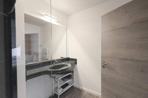 W łazience znajduje się umywalka i lustro. w obiekcie Ferienqaurtier- Forsthaus w mieście Bad Gottleuba