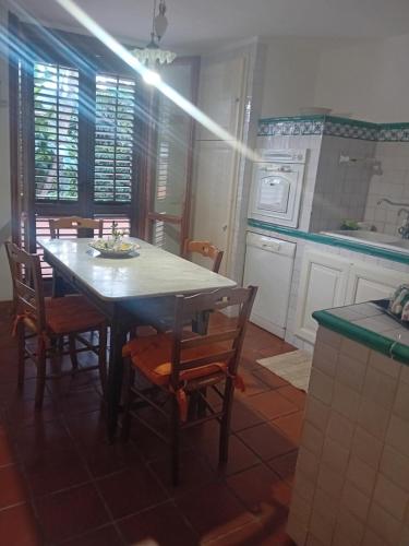 uma cozinha com uma mesa e cadeiras numa cozinha em Villa venere e spa em Palermo