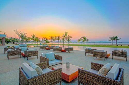 een patio met stoelen en tafels bij zonsondergang bij Amaya Beach Passikudah in Pasikuda