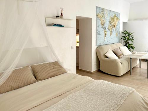 um quarto com uma cama, um sofá e uma cadeira em Duna em Tarifa