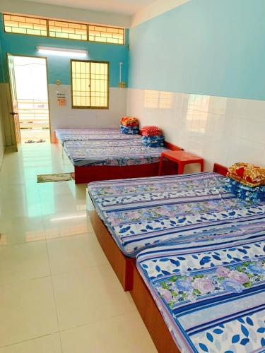 uma fila de camas num quarto com em Nhà Trọ Số 2 em áº¤p VÄ©nh ÃÃ´ng