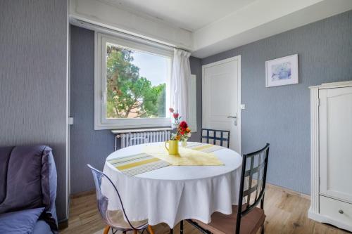 une salle à manger avec une table blanche et une fenêtre dans l'établissement Angelina - La002, à Cagnes-sur-Mer