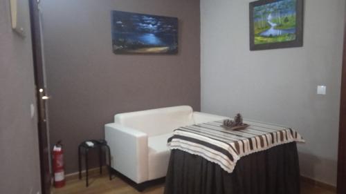 a living room with a white chair and a table at Apartamento Casa Romero in El Bosque