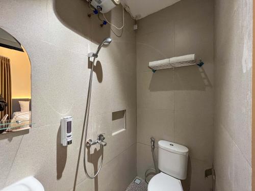 a bathroom with a shower and a toilet in it at SANS Hotel Premiere Majapahit Semarang in Semarang