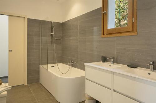 ein Badezimmer mit einer Badewanne, einem Waschbecken und einer Badewanne in der Unterkunft Villa Cintolino in Brando