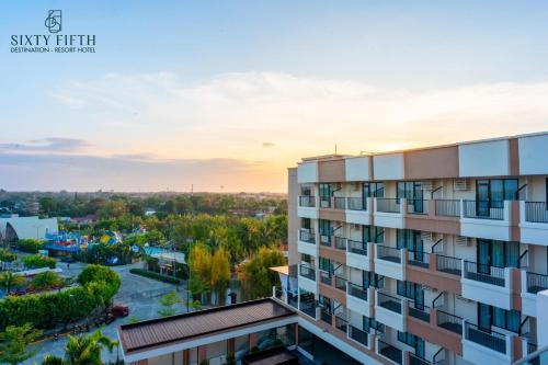 バコロドにあるSixtyFifth Destination Resort Hotelの夕日を背景に見えるアパートメントビル