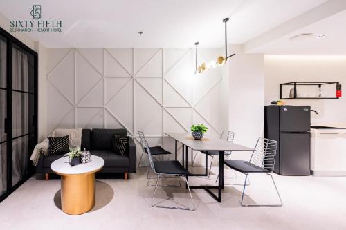 a living room with a table and chairs and a refrigerator at SixtyFifth Destination Resort Hotel in Bacolod